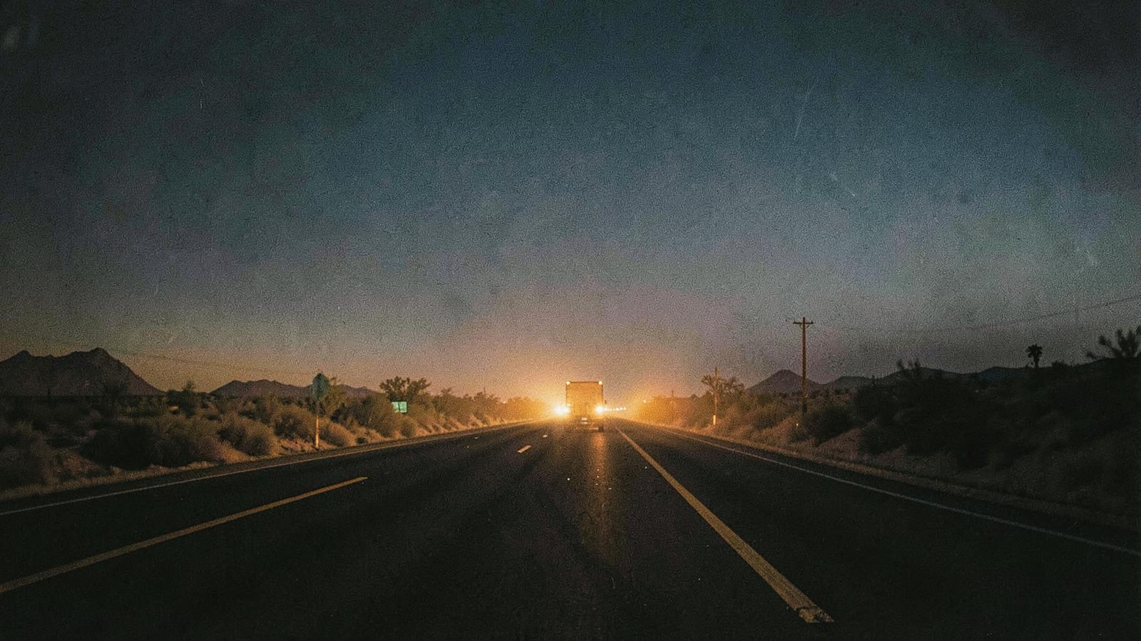 A lonely desert highway at dusk.
